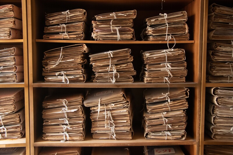 bundled folders stacked on shelf