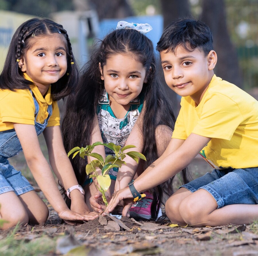 Three children planting a seedling